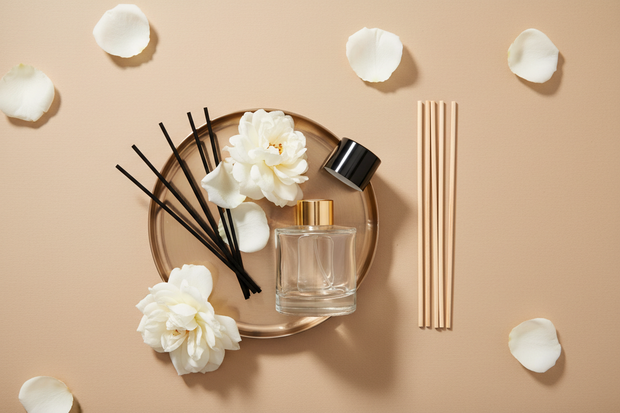 Artsy reed diffuser flat lay with rose petals